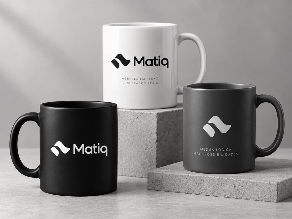 Three mugs with the Matiq logo, in white, black and gray, on concrete blocks.